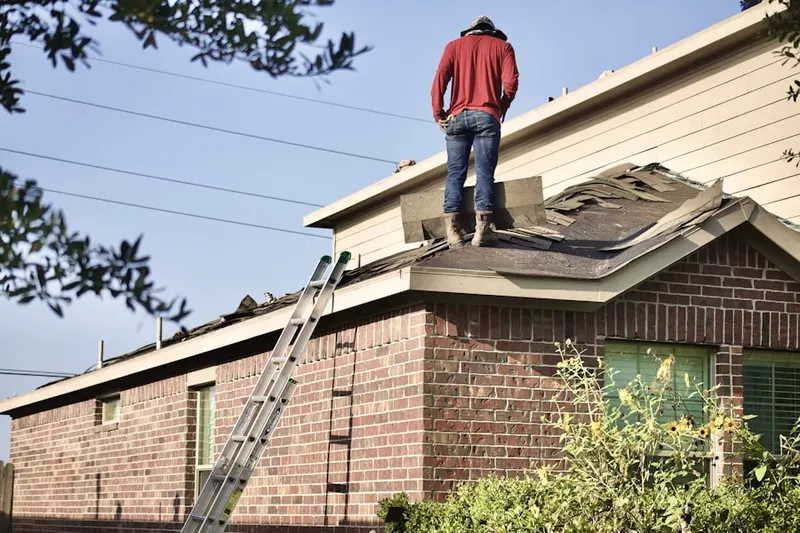 Professional roofer working on a residential roof in Houghton